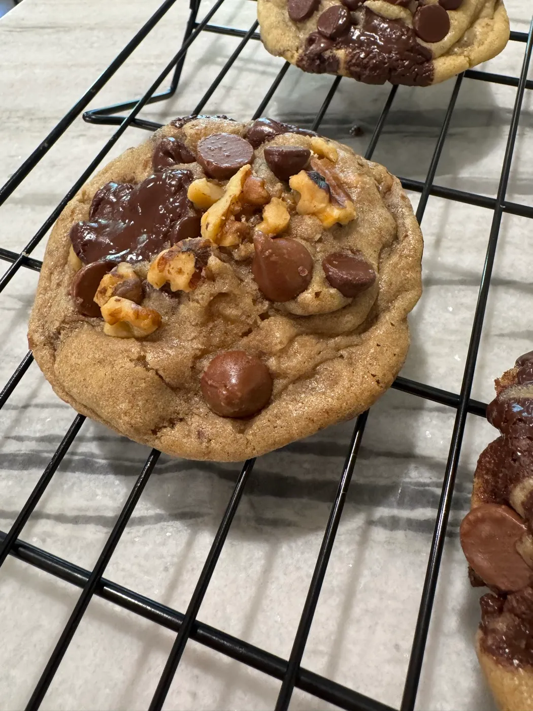 Freshly baked chocolate chip cookies cooling on a wire rack